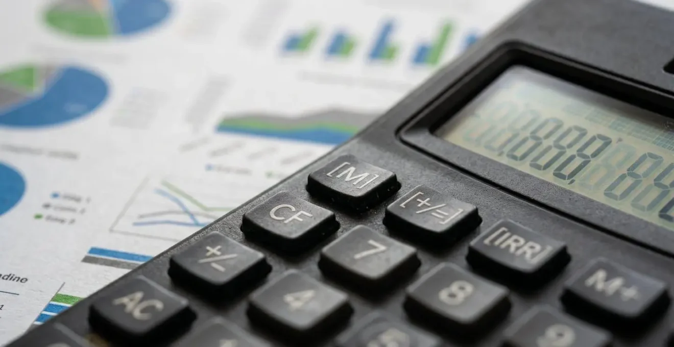 Calcolatrice e documenti finanziari per valutazione immobiliare a reddito